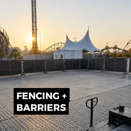Temporary fencing and barriers installed around an outdoor event area for perimeter and access control.